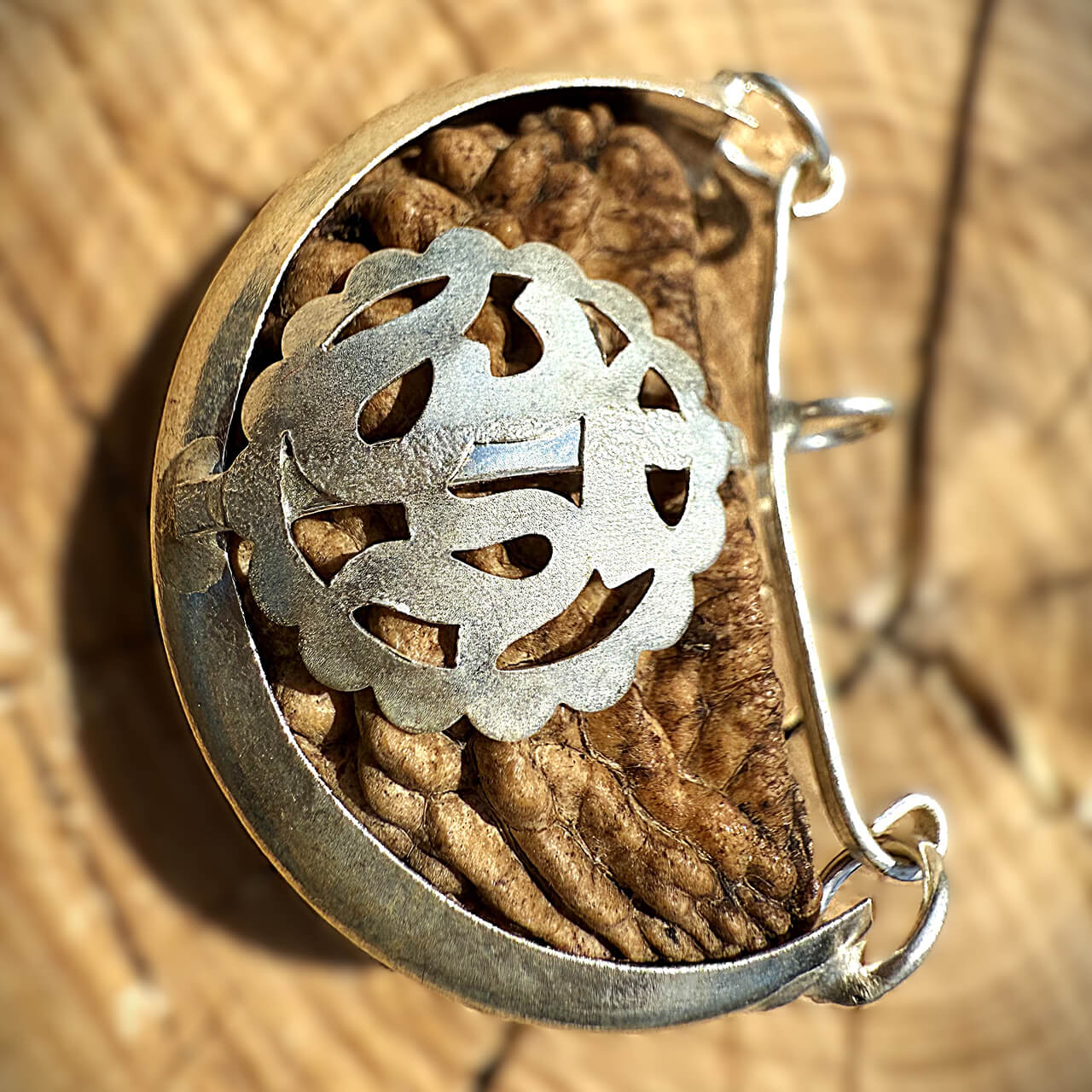 Top view of 1 Mukhi Rudraksha (Kaju Dana) on wooden block with blurred background highlighting its smooth, single-faced surface