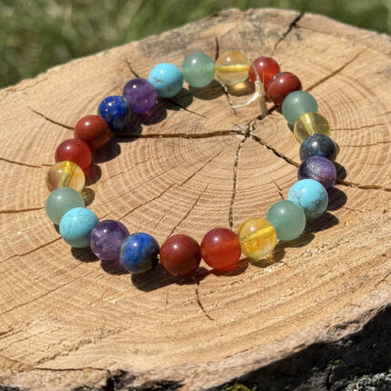 7 Chakra crystal bracelet on wooden block with blurred garden background