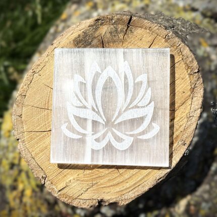 Front view of lotus-engraved Selenite charging plate on wooden block