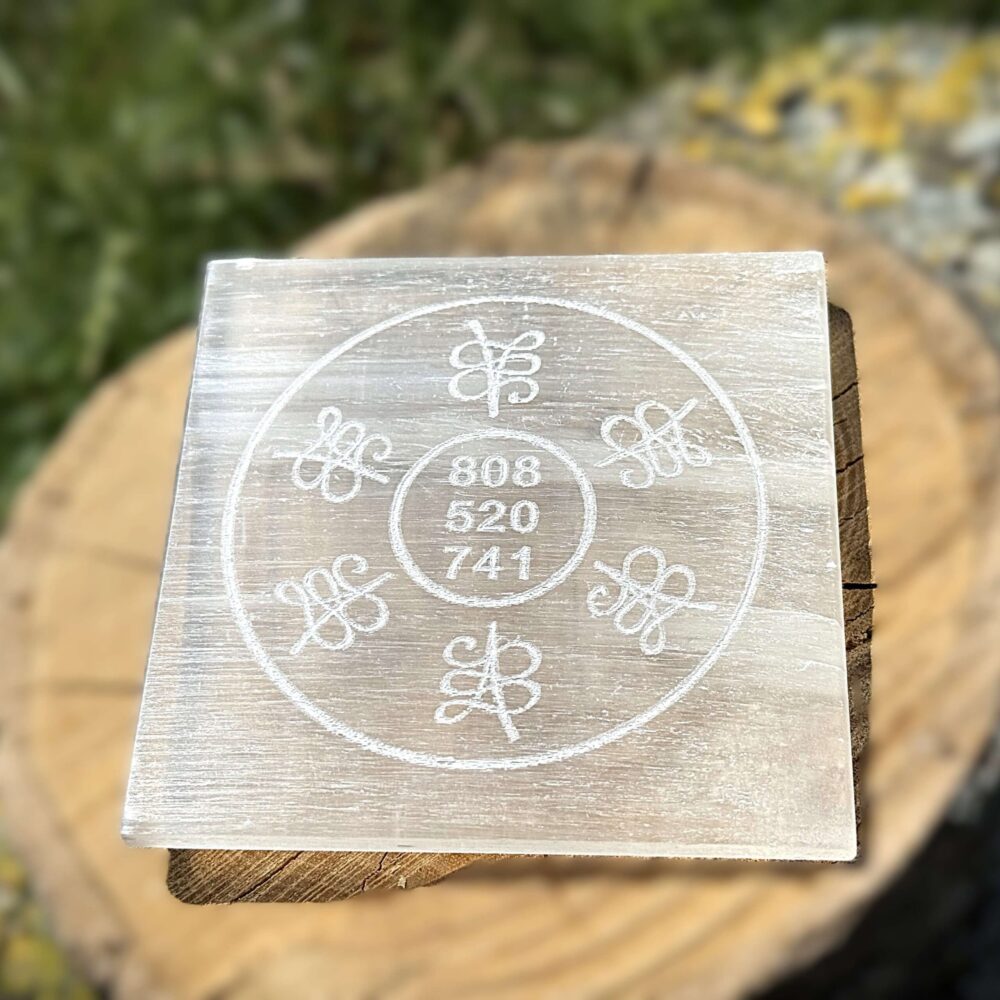Front-facing image of Grabovoi code engraved Selenite charging plate placed on a wooden surface
